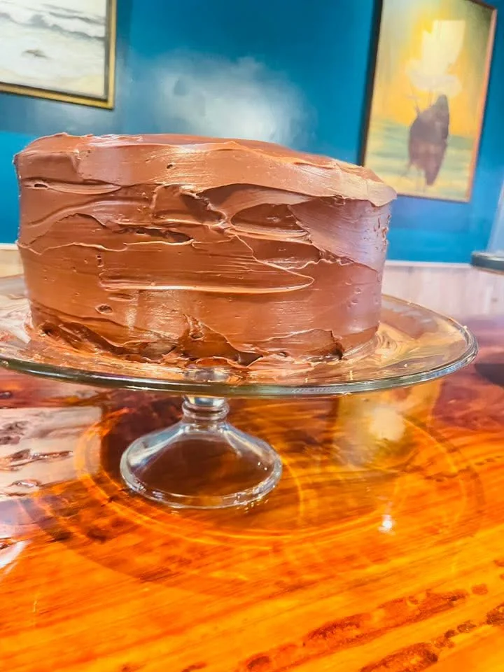Chocolate-frosted cake on a glass pedestal